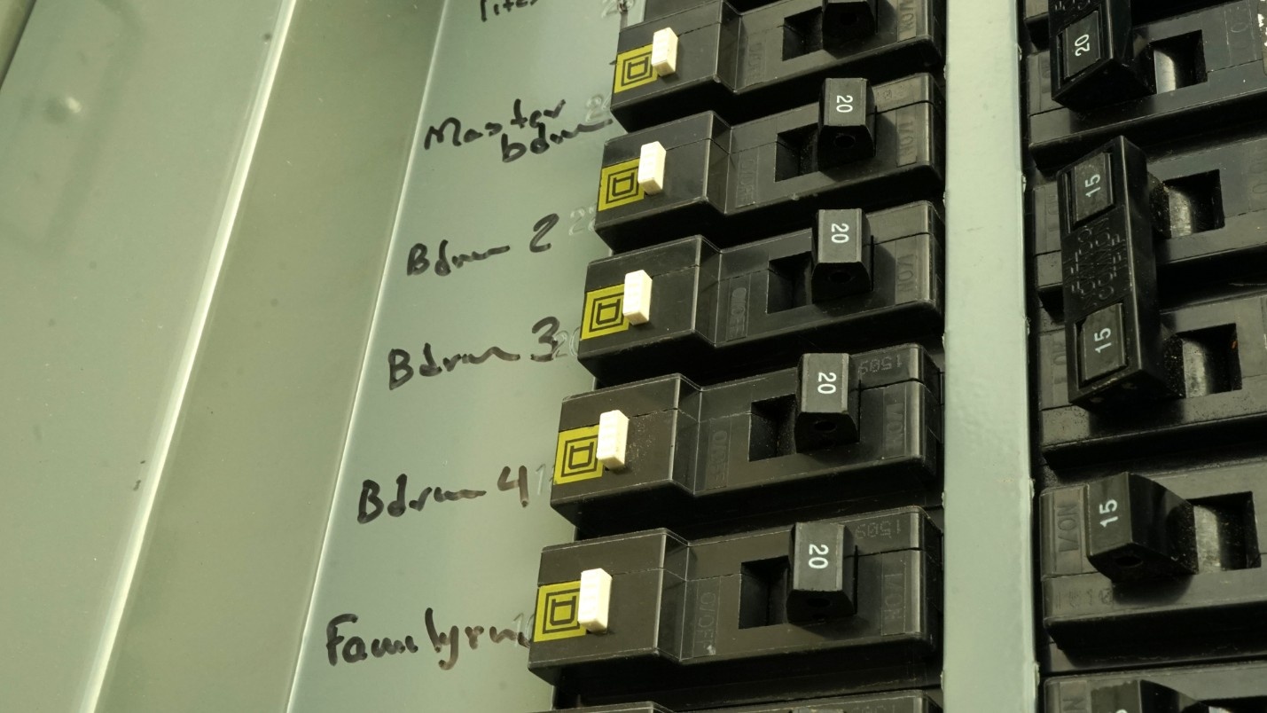 A close-up of a breaker box with each breaker laminated in ink.