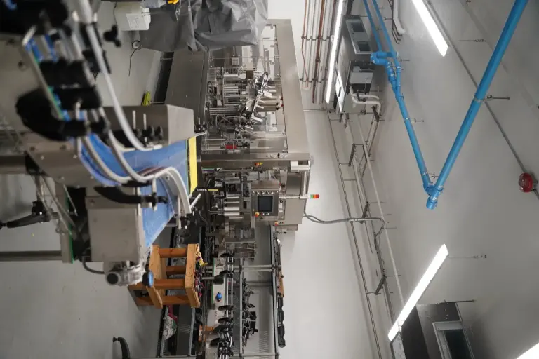 Bottling line in a production facility with overhead lighting