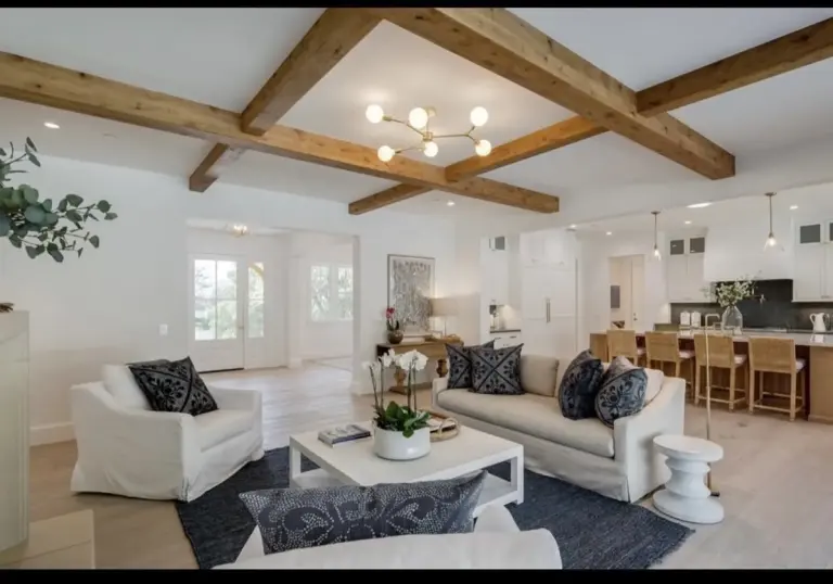 Living room with exposed beams and a modern chandelier
